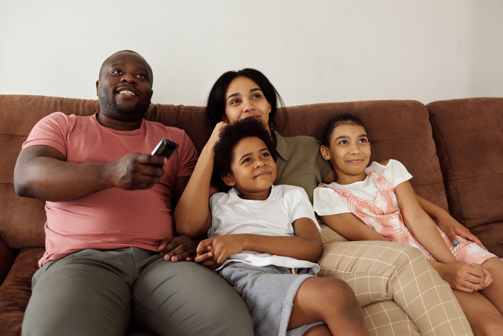 Familia viendo televisión junta en el living de su casa